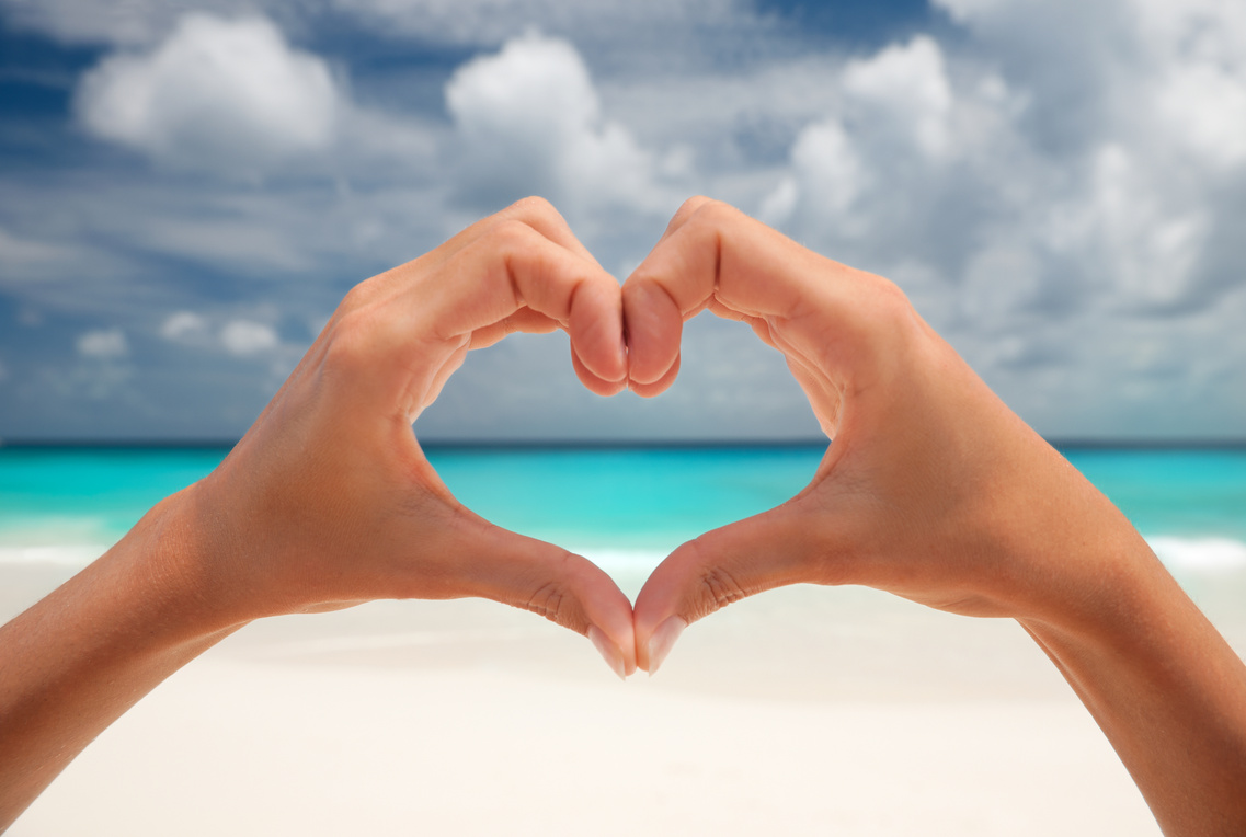 Heart gesture with hands at beach